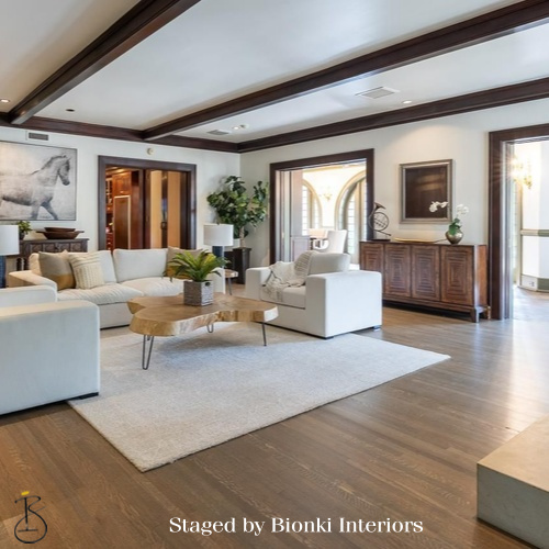 Luxury vacant home staging for a spacious living room featuring exposed beams and layered seating. Staged by Bionki Interiors.