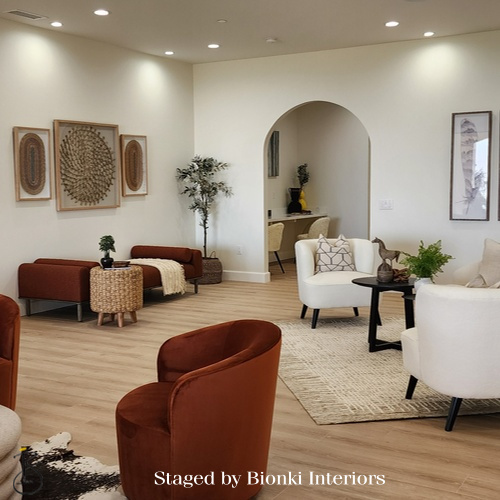 Luxury vacant home staging for a welcoming living space featuring arched architectural details and warm accent seating. Staged by Bionki Interiors.