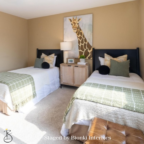 Luxury secondary bedroom staging featuring twin beds and coordinated bedding for family living. Staged by Bionki Interiors.