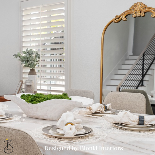 Custom dining area design featuring layered table styling and an antique-inspired mirror. Designed by Bionki Interiors.