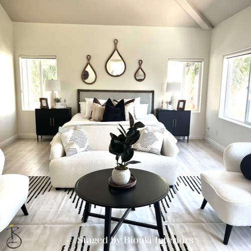 Luxury primary bedroom staging with symmetrical layout and thoughtfully layered bedding designed for buyer appeal. Staged by Bionki Interiors.
