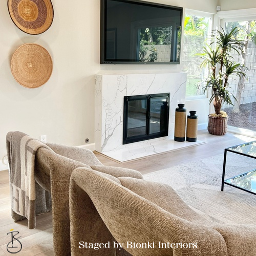 Luxury living room staging featuring a fireplace focal point and warm neutral tones designed for gathering. Staged by Bionki Interiors.