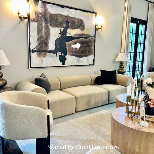 Luxury living room staging featuring sculptural seating, a soft neutral palette, and statement artwork designed for entertaining. Staged by Bionki Interiors.