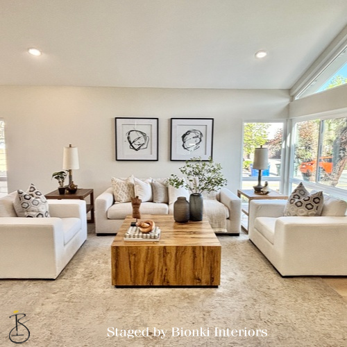 Luxury vacant home staging for a spacious living room with symmetrical seating and warm wood accents highlighting scale and flow. Staged by Bionki Interiors.