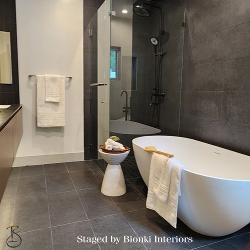 Luxury bathroom staging featuring a modern freestanding tub, oversized tile, and spa-inspired accessories designed to elevate the presentation. Staged by Bionki Interiors.