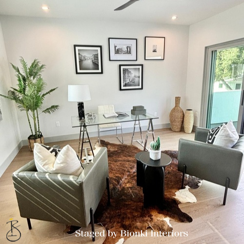 Luxury open-concept staging featuring a living area with an adjacent workspace and cohesive styling. Staged by Bionki Interiors.