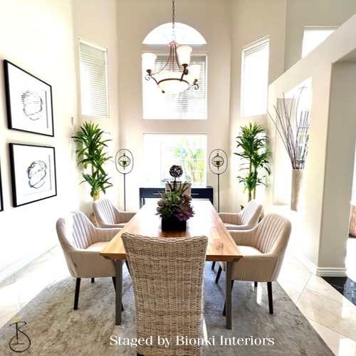 Luxury dining room staging in a light-filled space featuring an elongated table and upholstered seating. Staged by Bionki Interiors.
