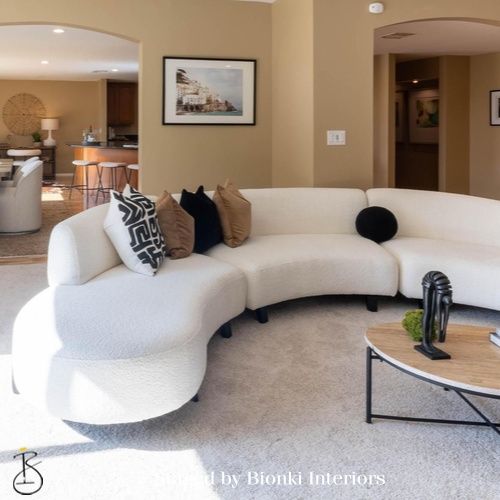 Luxury vacant home staging for a modern living room featuring curved seating and soft textures. Staged by Bionki Interiors.
