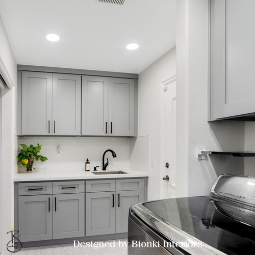 Custom laundry room design featuring tailored cabinetry and a clean neutral palette. Designed by Bionki Interiors.