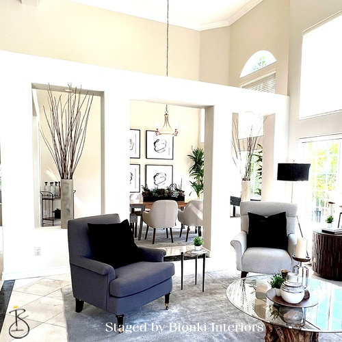 Luxury vacant home staging in a double-height living space filled with natural light, highlighting volume and architectural features. Staged by Bionki Interiors.