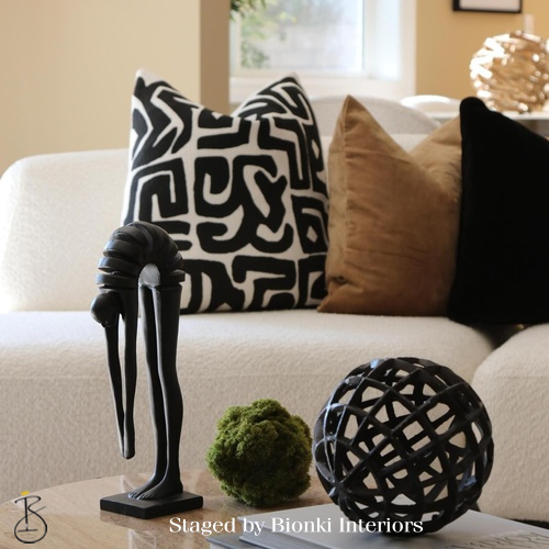 Luxury living room detail styling featuring sculptural accessories and patterned pillows. Styled by Bionki Interiors.