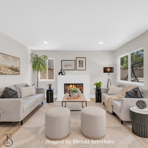 Luxury vacant home staging for a cozy living room featuring layered seating and warm neutral tones. Staged by Bionki Interiors.