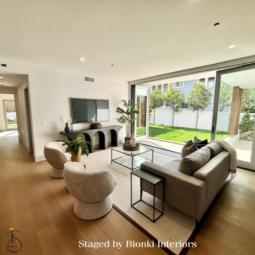 Luxury vacant home staging for a modern living room with expansive glass doors and indoor-outdoor flow. Staged by Bionki Interiors.
