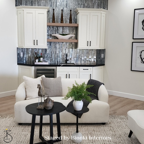 Luxury open-concept living and kitchen staging featuring cohesive furniture placement and layered textures. Staged by Bionki Interiors.