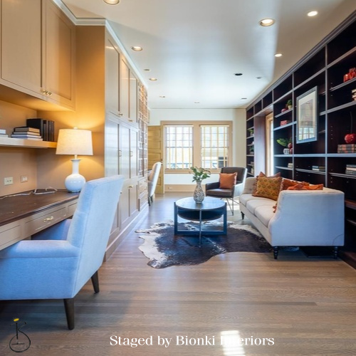 Luxury vacant home staging for a modern living room featuring built-in shelving and warm wood flooring. Staged by Bionki Interiors.