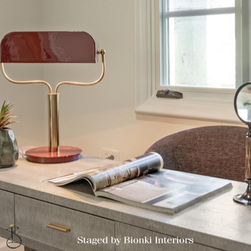 Luxury home office detail styling featuring sculptural desk lighting and layered accessories. Styled by Bionki Interiors.