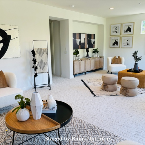 Luxury vacant home staging for a bright living room with layered furnishings and sculptural accents designed to enhance scale and flow. Staged by Bionki Interiors.