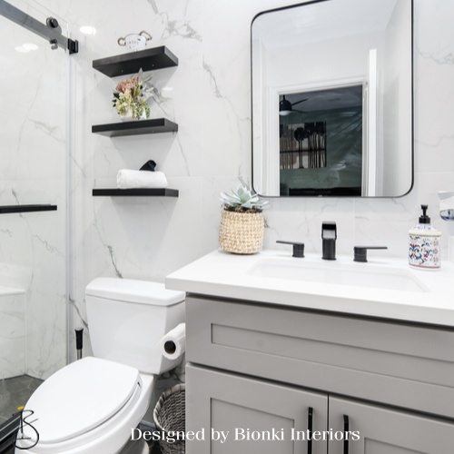 Custom bathroom design featuring floating shelving and clean-lined cabinetry. Designed by Bionki Interiors.