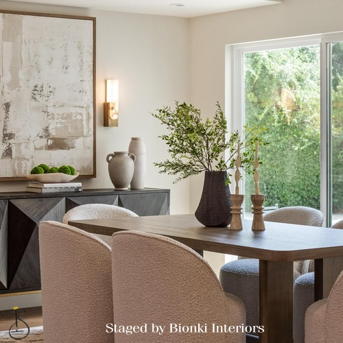 Luxury dining room staging featuring a natural wood table and upholstered seating. Staged by Bionki Interiors.